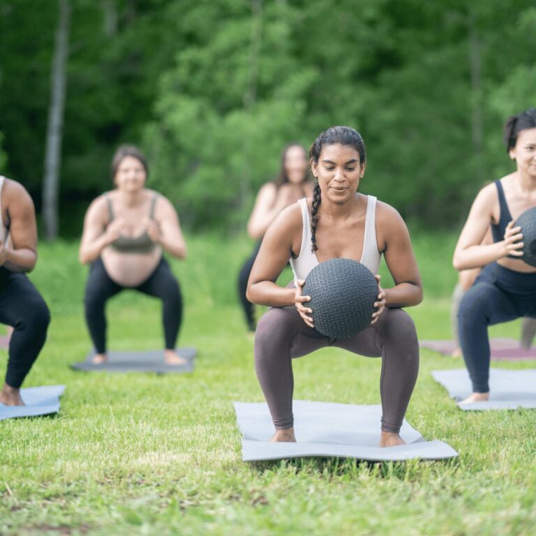 Women doing an outdoor group workout on the grass